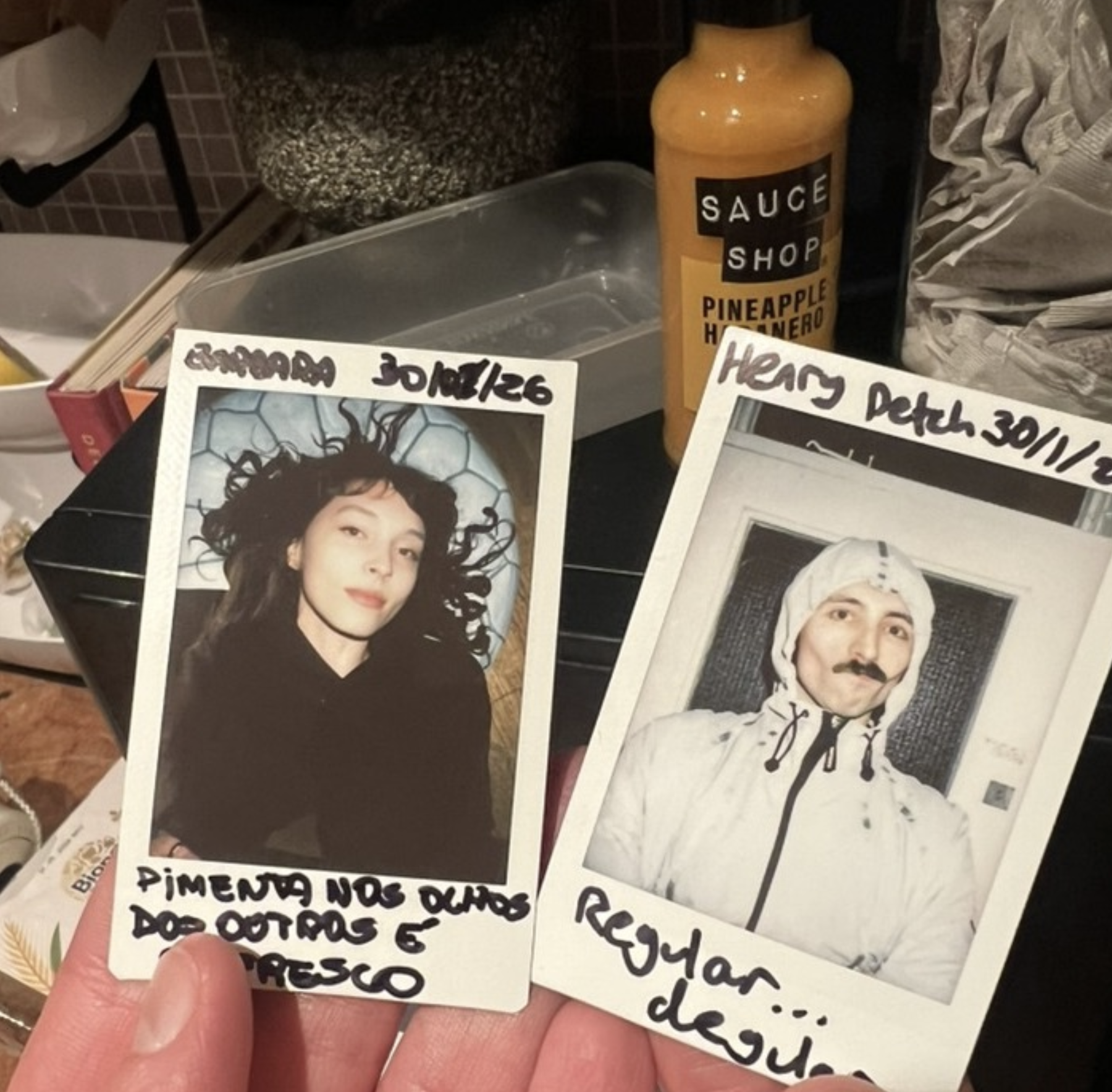 Barbara and Henry holding Polaroids